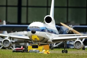 Detailed image of a large radio-controlled model airplane on grass with equipment.